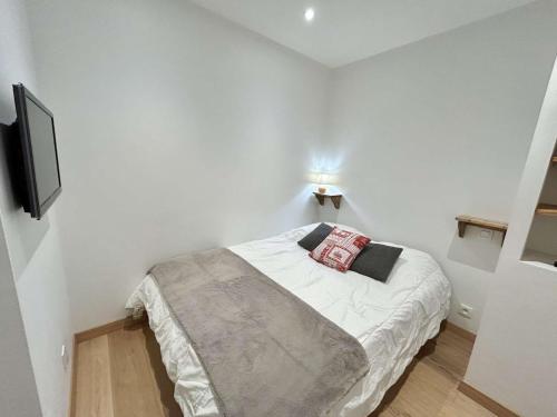 - une petite chambre blanche avec un lit et une télévision dans l'établissement Studios + Cabine à Megève, 4 Couchages, 500m des Remontées, Balcon Sud, Parking Inclus - FR-1-597-34, à Megève