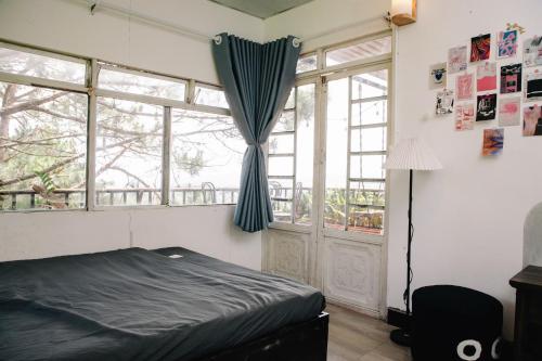 a bedroom with a bed and a window at Nhà Chạng Vạng in Ấp Ða Lợi