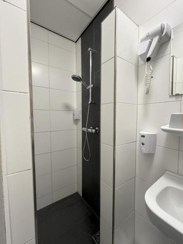 a bathroom with a shower and a sink at Hotel Breitner in Rotterdam