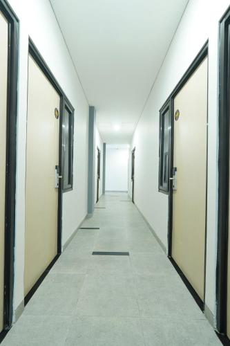 an empty corridor with doors in a building at Grand Valora Puspowarno Kostel in Kalibanteng-lor