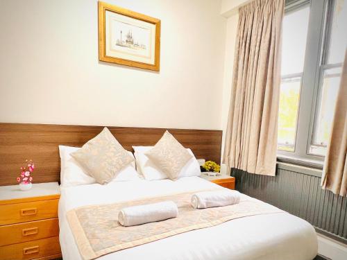 a bedroom with a bed with two pillows on it at Grainger House Hotel in Newcastle upon Tyne