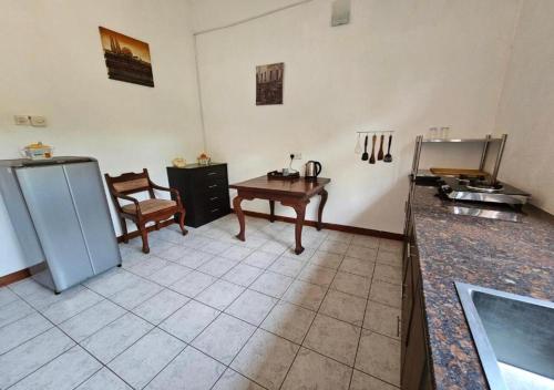 a kitchen with a refrigerator and a table in it at Green Village Negombo in Negombo
