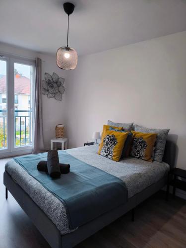 - une chambre avec un lit doté d'oreillers jaunes et gris dans l'établissement Bright flat near Disneyland with private parking, à Chalifert