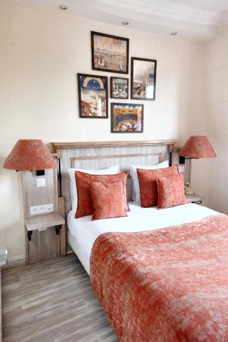 a bedroom with a large bed with red pillows at Hôtel du Château in Vincennes