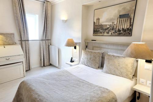 a bedroom with a bed and a painting on the wall at Hôtel du Château in Vincennes
