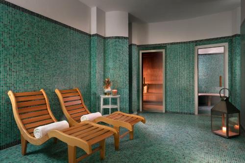 two chairs in a room with green tiled walls at Sina Villa Medici, Autograph Collection in Florence