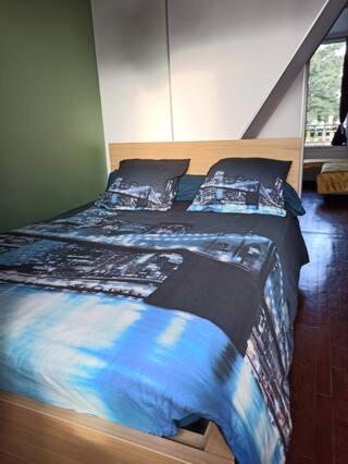 - une chambre avec 2 lits dotés de draps et d'oreillers bleus dans l'établissement 30 minutes du Parc Floral - Suite privative, à Champigny-sur-Marne