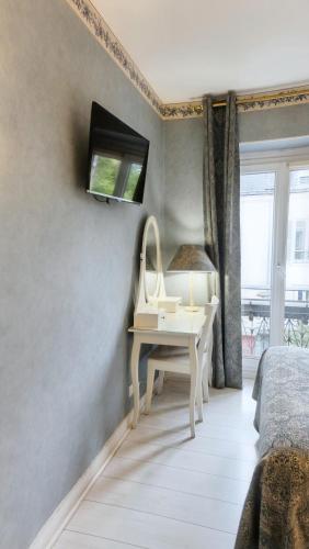 a bedroom with a dressing table and a mirror at Hôtel du Château in Vincennes