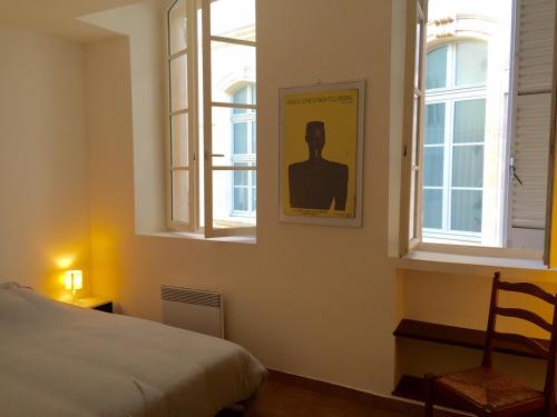 a bedroom with a bed and two windows at Panier in Marseille