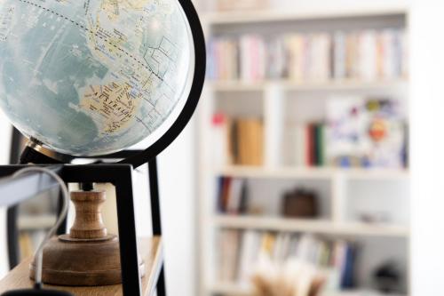 a globe on a stand in front of a book shelf at Casa Ines in Rome