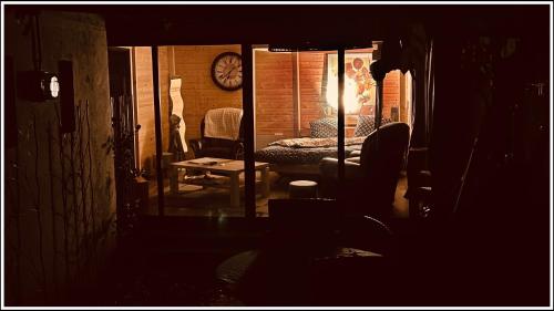 a dark room with a bed and a chair at Ô Jardin Secret in Oberschaeffolsheim
