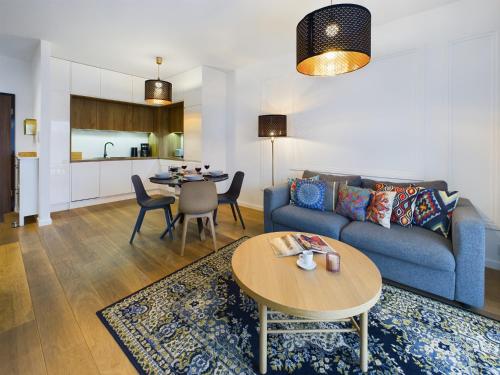 een woonkamer met een blauwe bank en een tafel bij Apartments GO Rakowicka by Noclegi Renters in Krakau