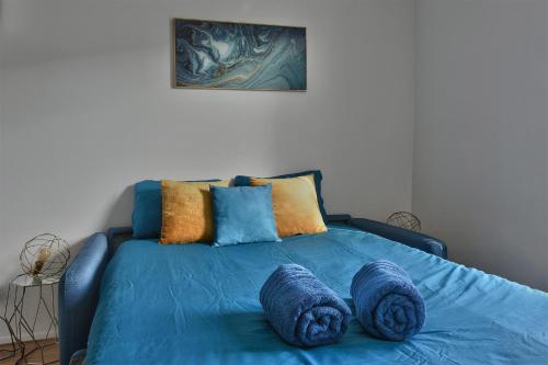 - un lit bleu avec des oreillers bleus au-dessus dans l'établissement 