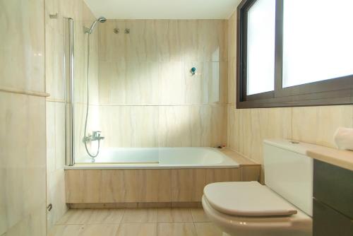 un bagno con vasca, WC e doccia di WELCS APARTAMENTO 189 PDA con piscina comunitaria a S'Agaró