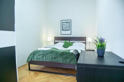 a bedroom with a bed and a table with a plant at Comfortable 2BR Apt, Near Wiener Stadthalle in Vienna