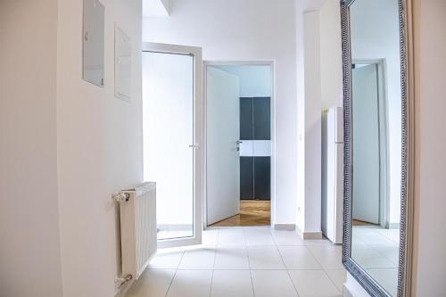 a mirror in a hallway with a white hallway at Comfortable 2BR Apt, Near Wiener Stadthalle in Vienna