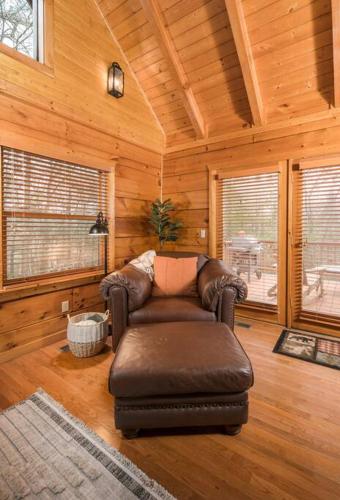 a living room with a leather chair in a cabin at Wrap-Around Porch, Hot Tub and Game Room in Blowing Rock