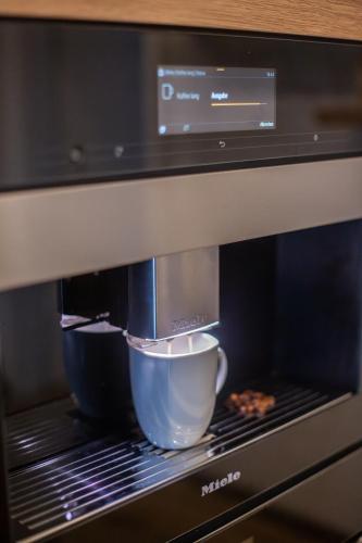 a coffee maker with a cup in a microwave at Winkelschiffchen III mit Sauna in Juist