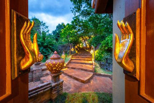a view through a door of a garden with lights at Kanlaya's Eyrie, Luxury Homestay in Pang Mapha