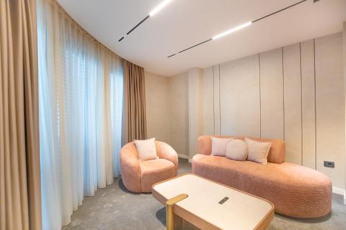 a room with a couch and a chair and a table at Metropol Hotel in Ferizaj