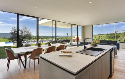 eine Küche und ein Esszimmer mit großen Glasfenstern in der Unterkunft Villa Rosinjola in Nova Vas