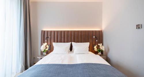 a bedroom with a large bed with a wooden headboard at Aiden by Best Western Biberach in Biberach an der Riß