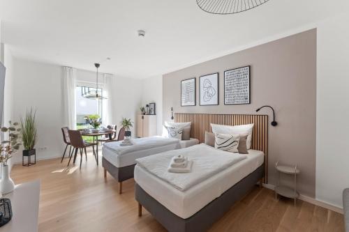 a bedroom with two beds and a dining room at kitchenroombed - Top City-Lage I nahe Hbf I bis 5P I Aufzug I Tiefgarage I Terrasse in Halle an der Saale