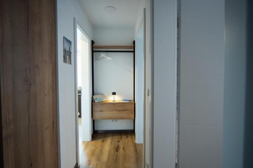 a hallway with a table and a desk with a lamp at Winkelschiffchen III mit Sauna in Juist