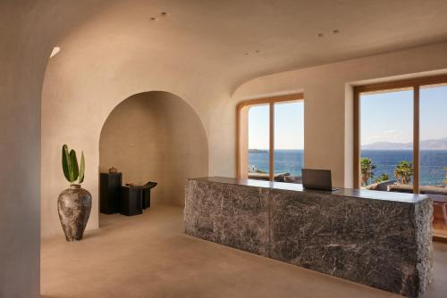 a lobby with a counter with a view of the ocean at Mykonos Earth Suites in Mýkonos City