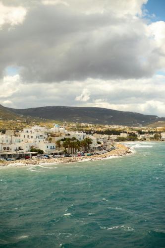 a view of a beach with white buildings and the ocean at Golden Sand in Plaka