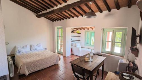 ein Schlafzimmer mit Bett, Tisch und Fenstern in der Unterkunft Il Plumbago - Elba Affitti in Mortigliano