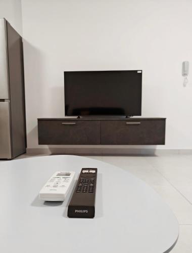 a tv and two remote controls sitting on a table at Blue Pearl in Żurrieq