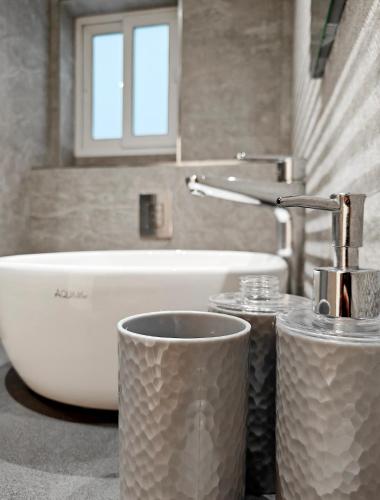 a bathroom with a sink and a tub and two cups at Blue Pearl in Żurrieq