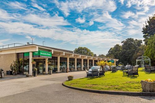 a building with chairs in front of a parking lot at Britannia Leeds Bradford Airport in Bramhope