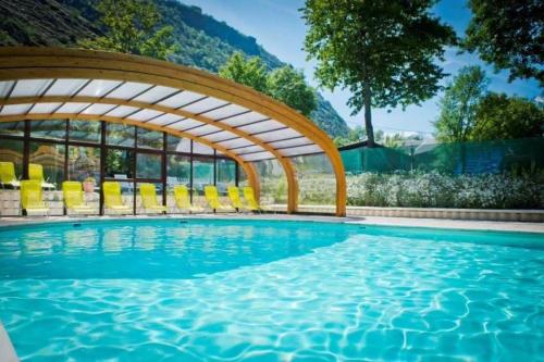 una piscina con sedie gialle e un arco sopra di essa di Camping 5 étoiles - Piscine - eeceff a Le Bourg-dʼOisans