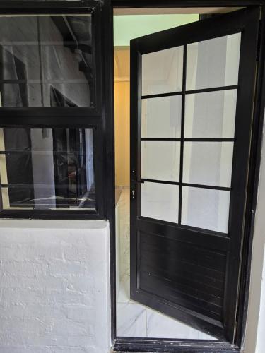 a black door with glass windows in a room at 55 New Street, Makhanda in Grahamstown
