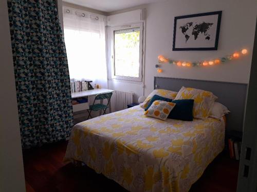 une chambre avec un lit, un bureau et une fenêtre dans l'établissement Appartement spacieux, à 20 min de gare St Lazare, à Asnières-sur-Seine