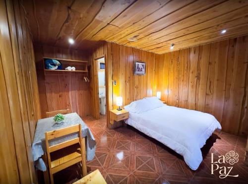 a bedroom with a large bed in a wooden room at Hotel La Paz in Poasito