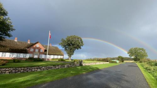 a rainbow over a house and a road at Bjerremark Hotel og Kursuscenter in Tønder