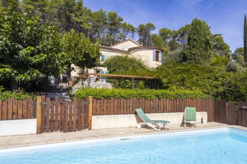 une piscine avec 2 chaises longues et une maison dans l'établissement Gîte Nature, à Lorgues