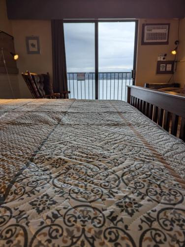 a bedroom with a bed with a view of the ocean at Above Tide Motel in Campbell River