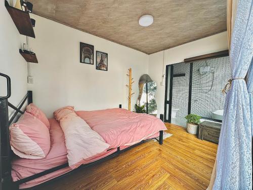 a bedroom with a large bed with pink sheets at Nhà Chạng Vạng in Ấp Ða Lợi