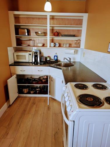 a kitchen with a white stove and a sink at Above Tide Motel in Campbell River