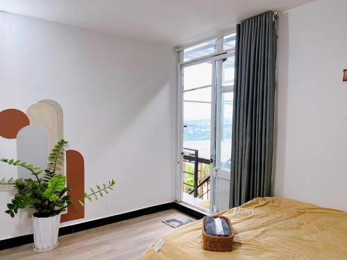 a bedroom with a bed and a large window at Nhà Chạng Vạng in Ấp Ða Lợi