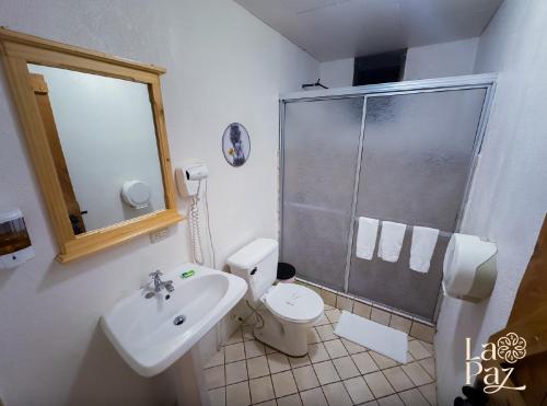 a bathroom with a shower and a toilet and a sink at Hotel La Paz in Poasito