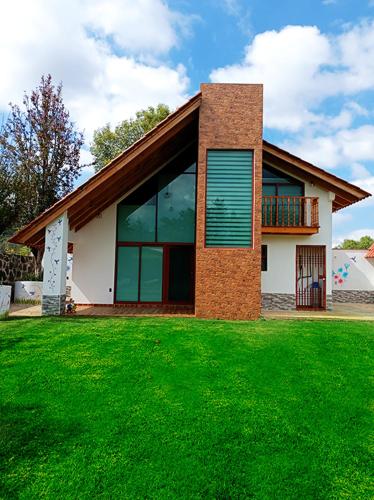 a house with a green lawn in front of it at Cabaña familiar en Huasca in Huasca de Ocampo