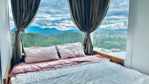 a bed in a room with a large window at Nhà Chạng Vạng in Ấp Ða Lợi