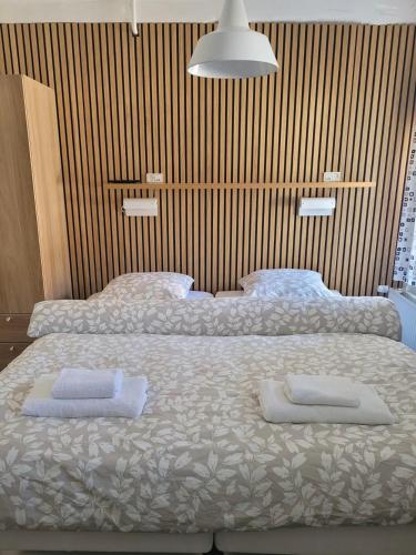 a bedroom with two beds with towels on them at Bjerremark Hotel og Kursuscenter in Tønder