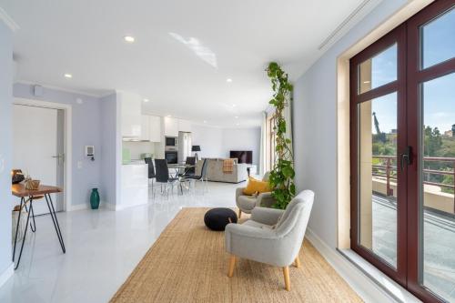 a living room with chairs and a living room with a balcony at Stay In St. Catarina Park, by PAUSA H. Rentals in Funchal