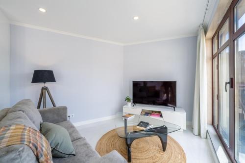 a living room with a couch and a tv at Stay In St. Catarina Park, by PAUSA H. Rentals in Funchal
